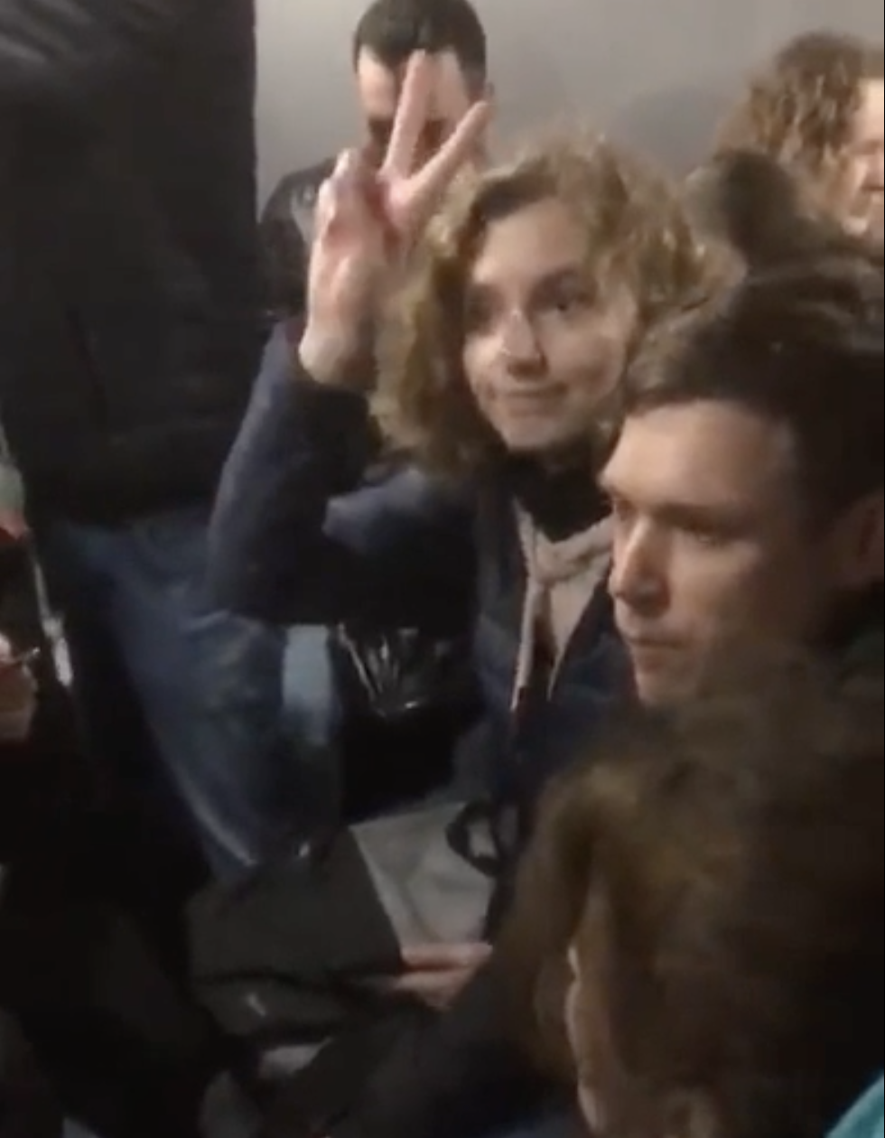 A protester in an auto-rack raises the peace sign while detained, St Petersburg, Sep 2022